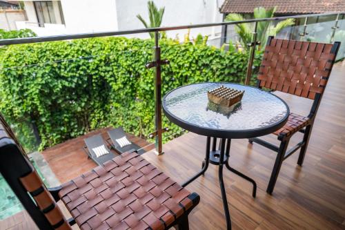 a glass table and two chairs on a balcony at Serenity Luxury Smart Villas with Private Pool, Canggu in Dalung