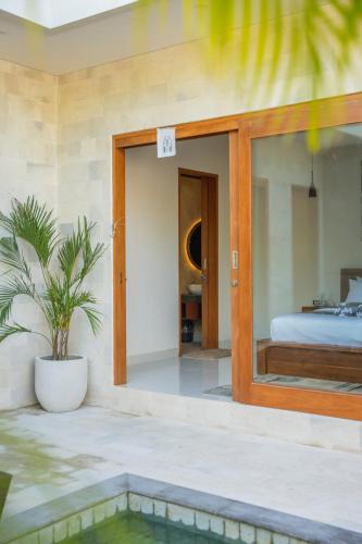 a bedroom with a bed and a potted plant at Niva Sanctuary - Family Friendly 2BR Villa with private pool - Between Sanur & Ubud in Ketewel