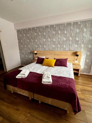 a bedroom with a large bed with two towels on it at Silesia Krynica in Krynica Zdrój