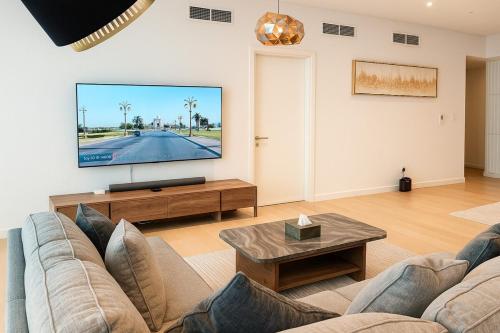 a living room with a couch and a flat screen tv at 2 BR Soul Beach Mamsha Sadiyaat - Partial Sea view in Abu Dhabi