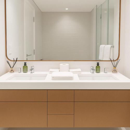 a bathroom with two sinks and a large mirror at 2 BR Soul Beach Mamsha Sadiyaat - Partial Sea view in Abu Dhabi