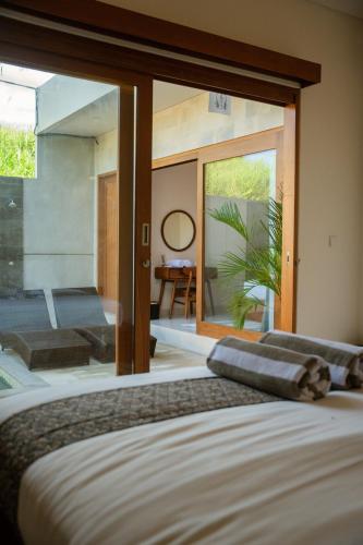 a bedroom with a bed and a large window at Niva Sanctuary - Family Friendly 2BR Villa with private pool - Between Sanur & Ubud in Ketewel