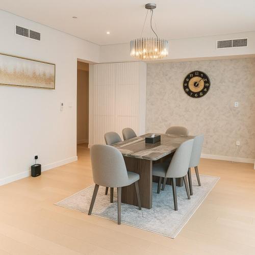 a dining room with a wooden table and chairs at 2 BR Soul Beach Mamsha Sadiyaat - Partial Sea view in Abu Dhabi