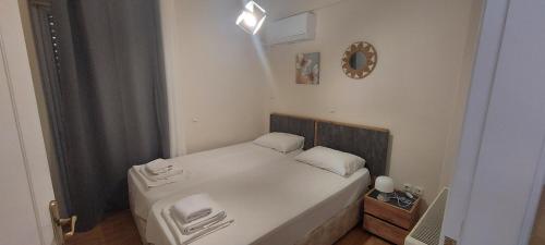 a small bedroom with a bed with white sheets at Harmony 5 in Áyios Spirídhon