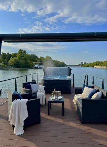 a deck with couches and a grill on the water at Prestige Yacht Resort Budapest in Budapest