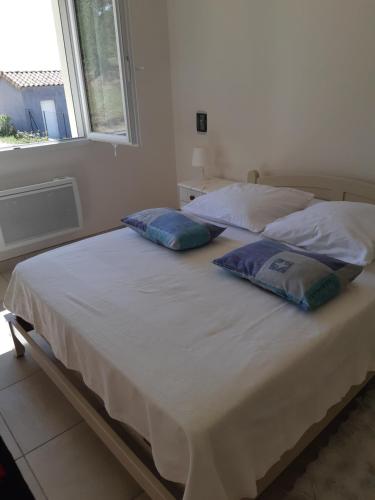 two pillows on a bed in a room with a window at villa soleil in Ruoms