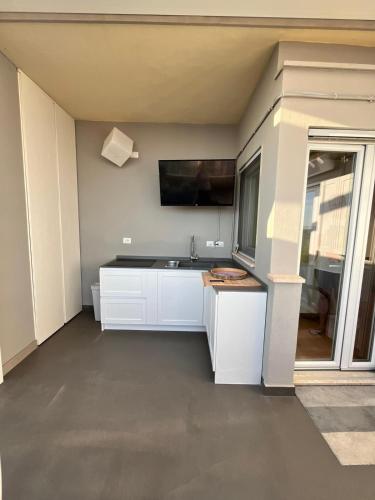 a kitchen with a sink and a tv on the wall at Terrazza sul mare in Ladispoli