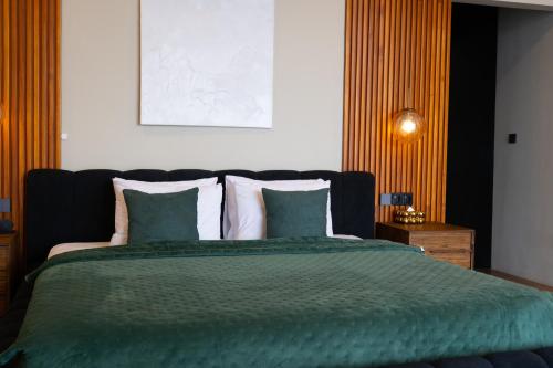 a bedroom with a bed with a green blanket and pillows at Serenity Luxury Smart Villas with Private Pool, Canggu in Dalung