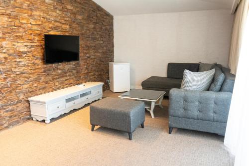a living room with a couch and a tv on a brick wall at Galata Fil Hotel in Istanbul