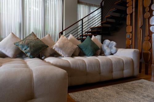 a living room with a white couch with pillows at Serenity Luxury Smart Villas with Private Pool, Canggu in Dalung