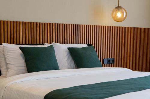 a bedroom with a bed with green and white pillows at Serenity Luxury Smart Villas with Private Pool, Canggu in Dalung