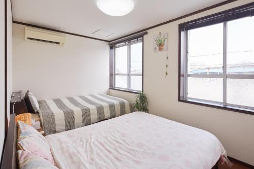 a small room with two beds and two windows at Wind Makiminato - Vacation STAY 73174v in Urasoe