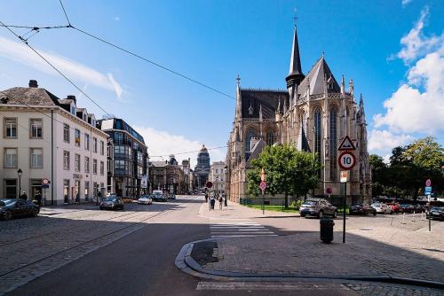 an empty city street with a church in the background at Maison Muse Sablon in Brussels
