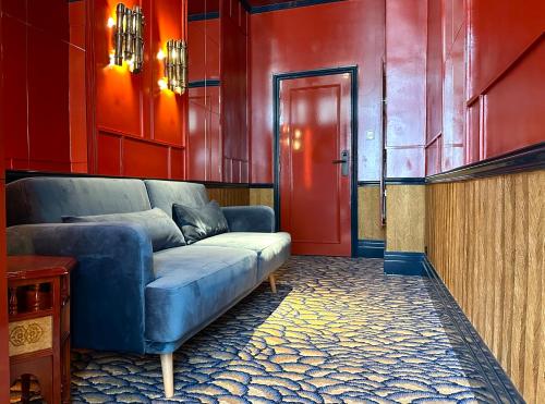 a living room with a blue couch and a red door at Maison Muse Sablon in Brussels