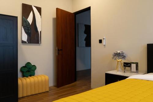a bedroom with a yellow bed and a door at Serenity Luxury Smart Villas with Private Pool, Canggu in Dalung