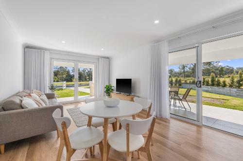 a living room with a couch and a table and chairs at Frazers Creek Escape