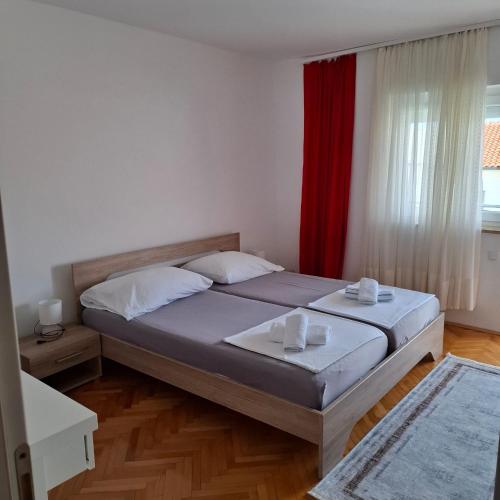 a bedroom with a bed and a red curtain at Jelly in Crikvenica