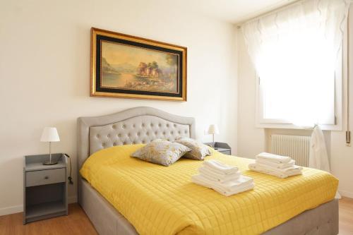 - une chambre avec un lit jaune et des serviettes dans l'établissement At the Tito Livio Passage - between history and modernity, à Padoue