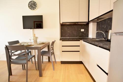 une cuisine avec une table et des chaises dans une pièce dans l'établissement At the Tito Livio Passage - between history and modernity, à Padoue