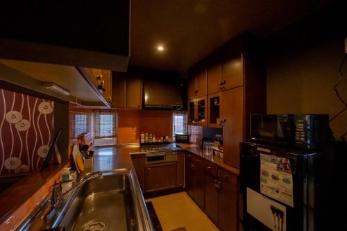 a kitchen with a sink and a microwave at sukeemon in Biei