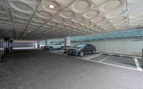 twee auto's staan geparkeerd op een parkeerplaats bij Song-Jeong Bay Hotel in Busan