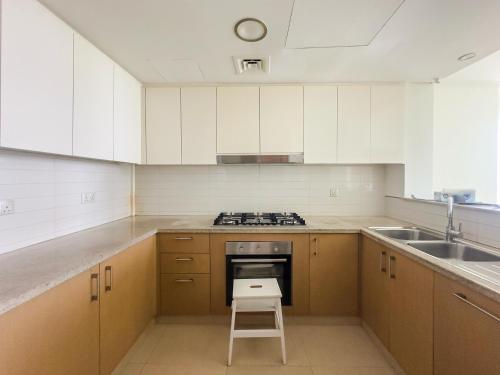 a kitchen with a stove and a stool in it at Private Sea View Room in 3BR Downtown Apartment Direct Mall & Metro Access in Dubai
