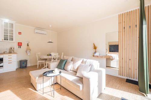 a living room with a white couch and a table at Cozy home with jacuzzi - near the airport in Ponta Delgada