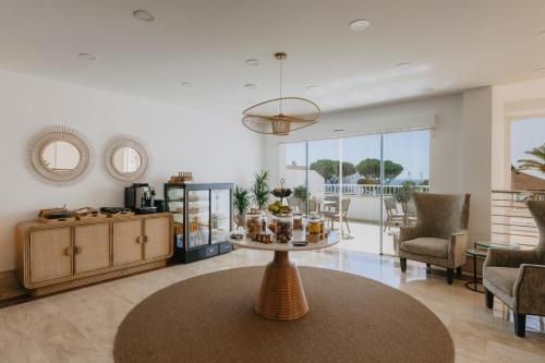 a living room with a table and chairs at Garden Playanatural - Adults Only in El Rompido