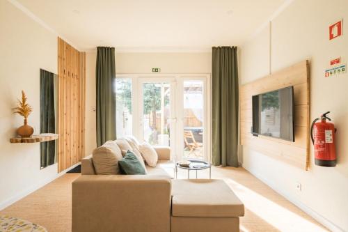 a living room with a couch and a window at Cozy home with jacuzzi - near the airport in Ponta Delgada