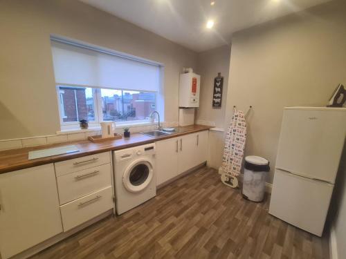 a kitchen with a sink and a washing machine at AA Exec Apartments in South Shields