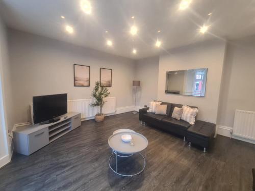 a living room with a couch and a tv at AA Exec Apartments in South Shields