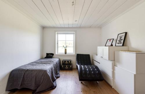 a bedroom with a bed and a chair in it at Stora Huset in Lindesberg