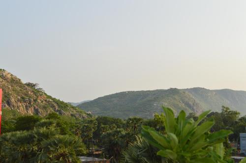 a mountain range with palm trees and mountains in the background at Aakarsh Hill View Hotel in Rājgīr