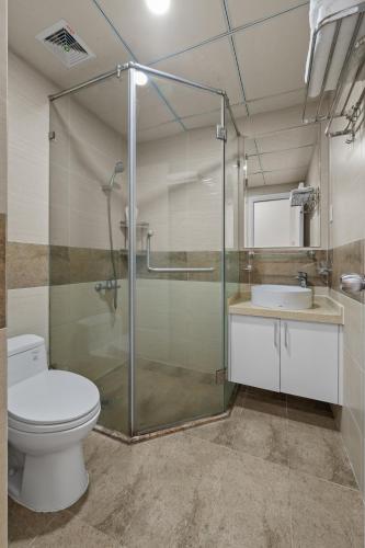 a bathroom with a shower and a toilet and a sink at Monarchy Riverside Da Nang - Modern Stay & Pool in Danang