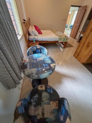a table with a glass top in a room with a bed at Nadhi Mane River-front Beach Stay in Tadri