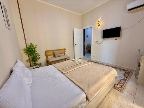 a bedroom with a bed and a tv and a chair at Velvet Casa - Downtown Cairo in Cairo
