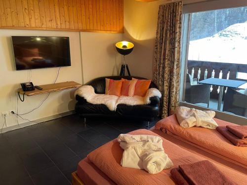 a room with two beds and a chair and a television at Castle A17 in Blitzingen
