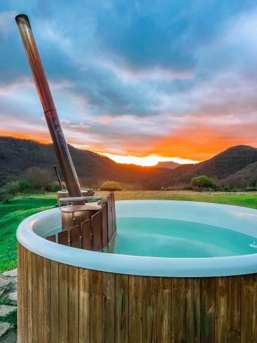 a hot tub with the sunset in the background at La casa de la masia in Susqueda