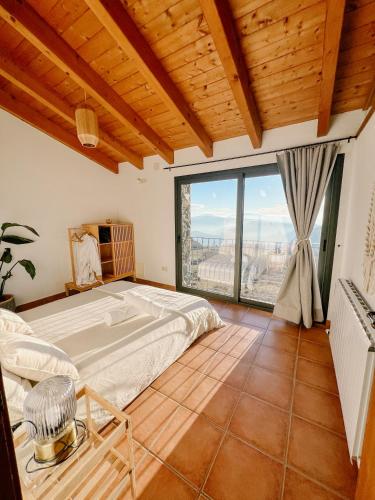 a bedroom with a bed and a large window at La casa de la masia in Susqueda