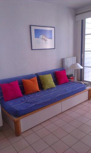 a blue couch with different colored pillows on it at Appartement Figure de proue, près Les Sables d Olonne, Talmont saint Hilaire in Talmont