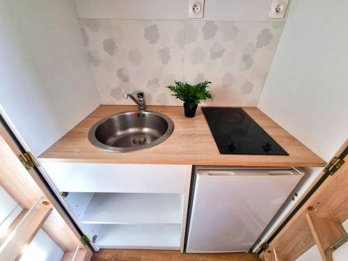 a small kitchen with a sink and a stove at Le calme à deux pas de tout in Elbeuf