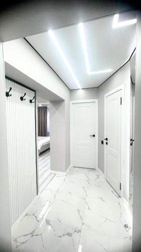a room with a white hallway with a white door at Проспект Жамбыла 115а люкс квартира in Taraz