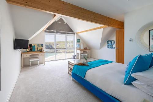 Un dormitorio con una cama y un escritorio con televisión. en Tides Edge, en Portreath