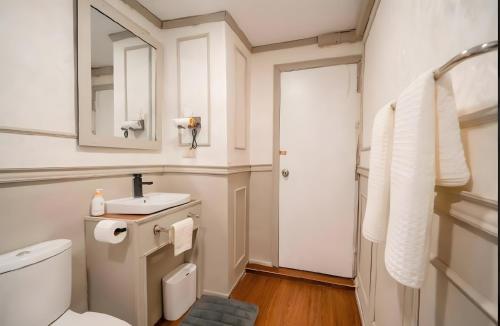 a bathroom with a toilet and a sink and a mirror at CASA Sukhumvit XI -ซอยสุขุมวิท 11 in Makkasan