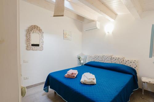 a bedroom with a blue bed with two towels on it at Casa del Golfo in Castellammare del Golfo