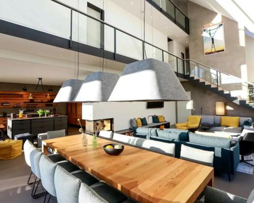 a living room with a wooden table and chairs at Nordic Bliss Cozy Villa with Jacuzzi & Sauna in Nørdstebø 
