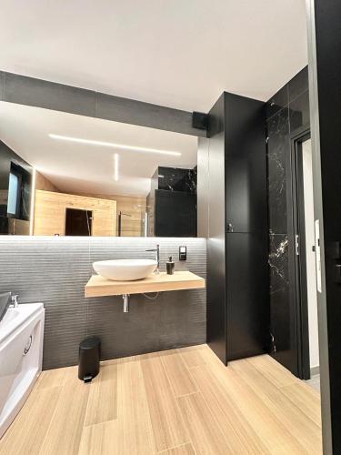 a bathroom with a sink and a large mirror at SPA Apartament Wisła prywatna sauna, jacuzzi i bilard in Wisła
