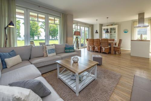 a living room with a couch and a table at Reethus am Strand - Haushälfte 2 mit Kamin, Sauna in Lobbe