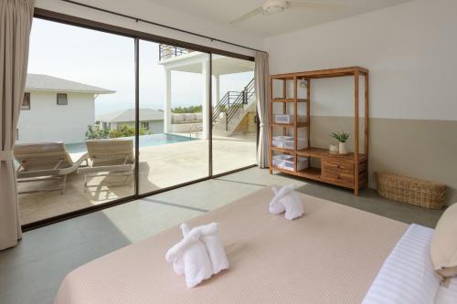 two towels on top of a bed in a bedroom at Sunset villa rooftop with pool 180 Seaview in Koh Phangan