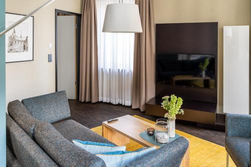 a living room with a couch and a table at The Green Rostock Apartment Hotel in Rostock